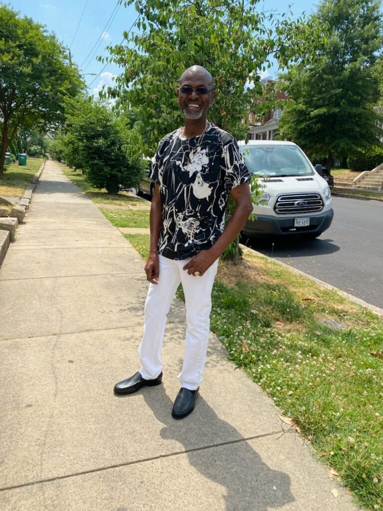 a full body picture of a smiling James Coleman